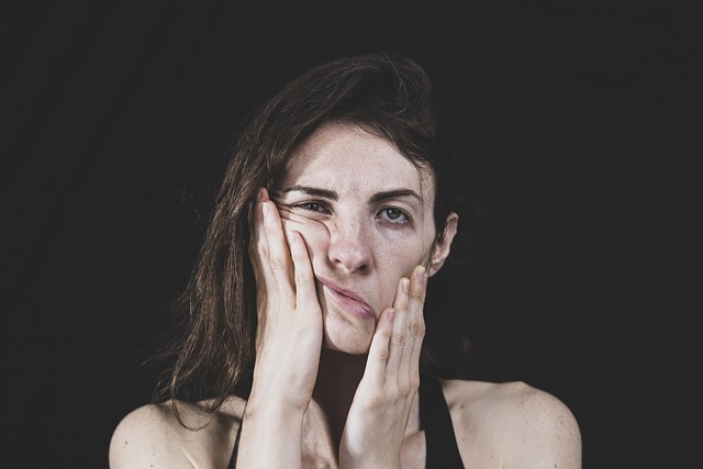 person looking stressed at a desk with many papers
